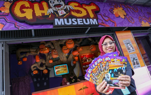 Ghost Museum Melaka entrance with staff member holding brochures.
