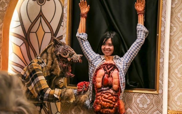 Visitor interacting with werewolf exhibit at Ghost Museum Melaka.