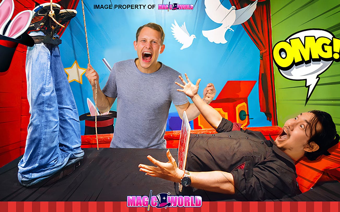 Man performing magic trick with levitating person at Magic World Penang.