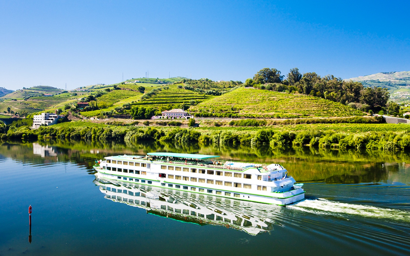Cruise ship on Douro River with vineyards in Pinhão, Portugal.