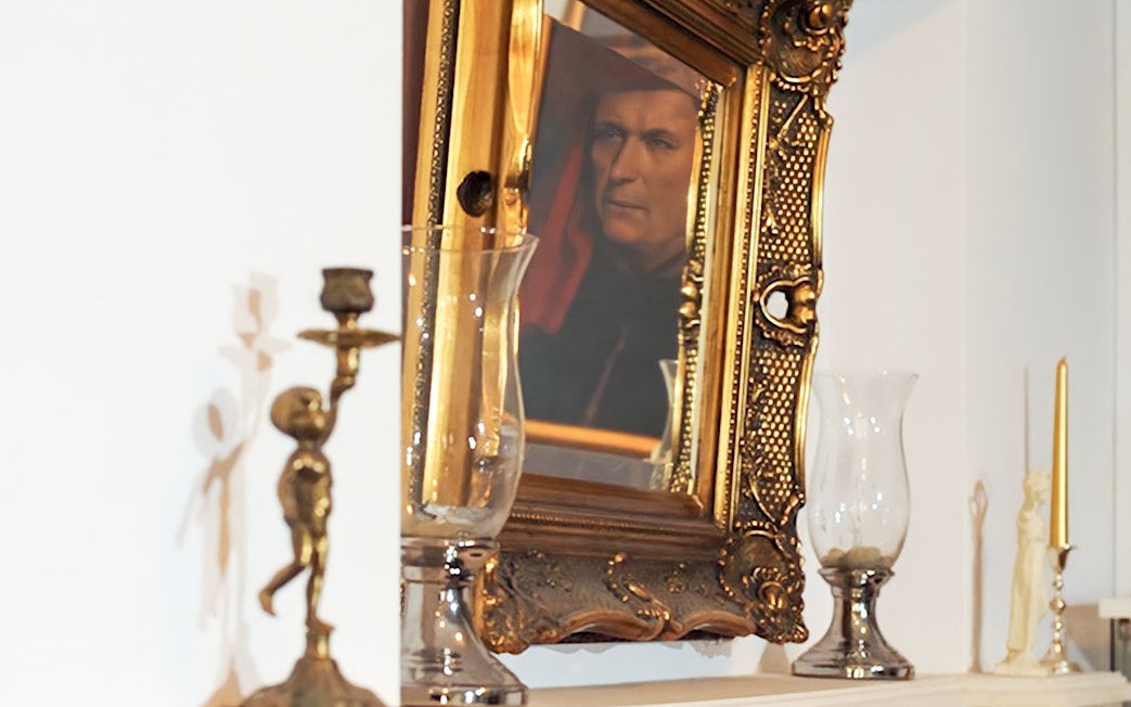 Reflection of a portrait in an ornate gold frame near candlesticks, related to Evening Chopin Piano Concert.