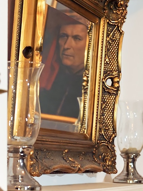 Reflection of a portrait in an ornate gold frame near candlesticks, related to Evening Chopin Piano Concert.