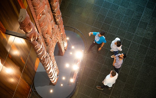 Visitors viewing Māori carvings at Museum of New Zealand Te Papa Tongarewa.
