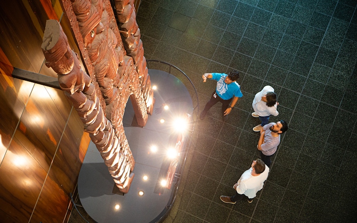 Visitors viewing Māori carvings at Museum of New Zealand Te Papa Tongarewa.