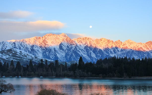 Sunrise over snow-capped mountains near Queenstown on the tour to Christchurch via Mt Cook and Lake Tekapo.