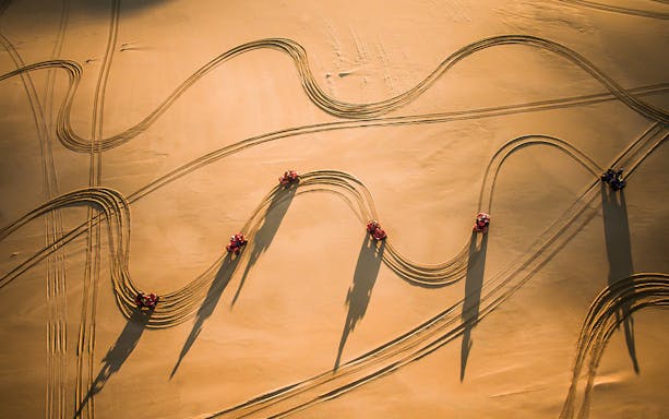 Quad bikes creating tracks on Stockton Beach sand dunes.