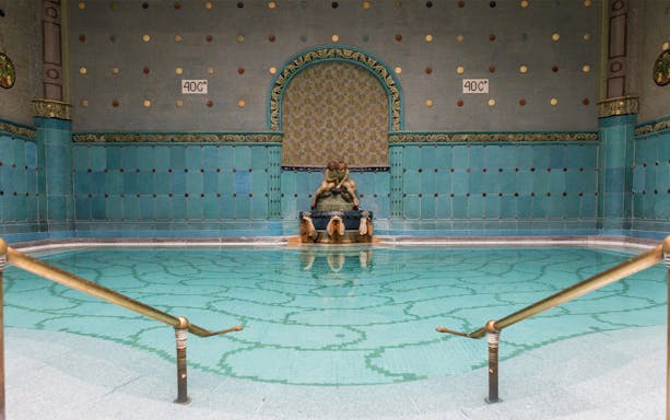 Gellert Bath thermal pool with ornate tiles and sculptures in Budapest.
