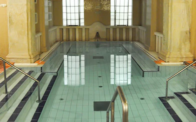 Lukacs Baths indoor pool with steps and handrails in Budapest.