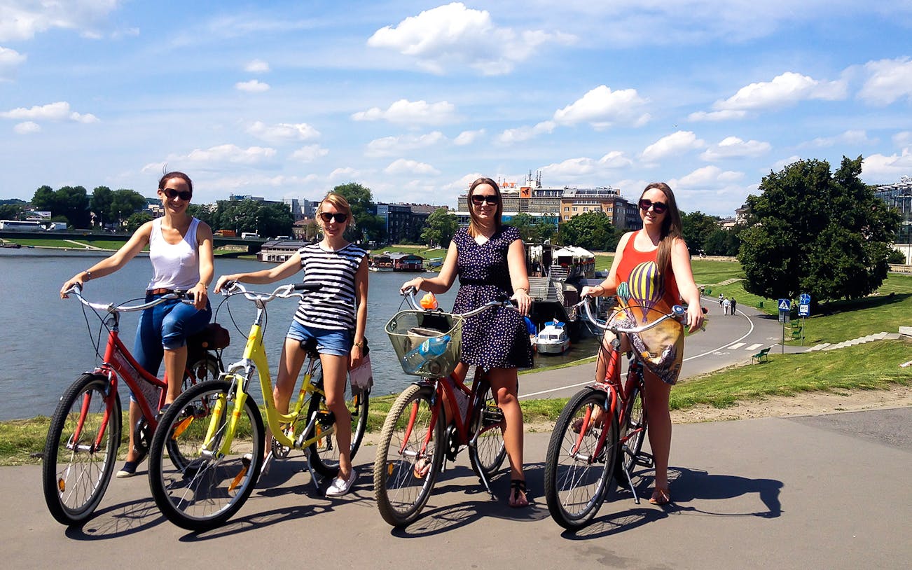 Group biking along a river path during a 4-hour guided city tour.