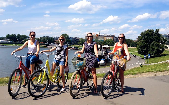 Group biking along a river path during a 4-hour guided city tour.