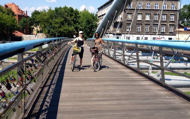 Cyclists on a bridge with love locks during a 4-hour guided bike city tour.