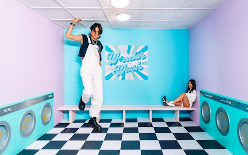 Visitors posing in a colorful laundry-themed room at Studio of Wonders.