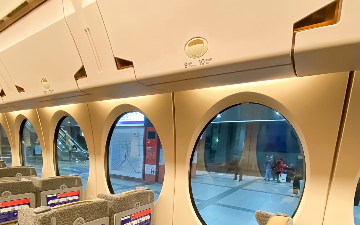Interior of Nankai Rapi:t train with round windows at Kansai Airport station.