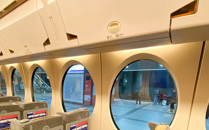 Interior of Nankai Rapi:t train with round windows at Kansai Airport station.