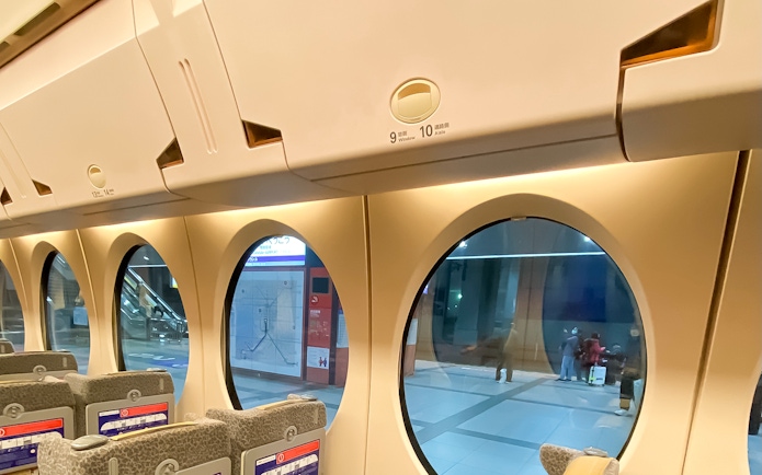 Interior of Nankai Rapi:t train with round windows at Kansai Airport station.