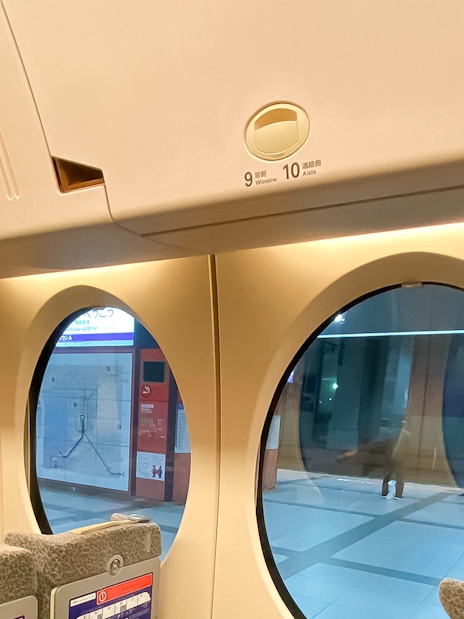 Interior of Nankai Rapi:t train with round windows at Kansai Airport station.
