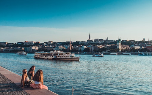 Boat tour on the Danube River in Budapest with cityscape in the background.