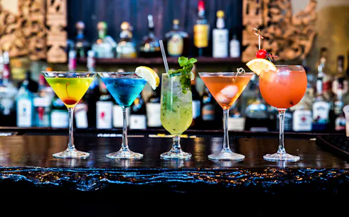Colorful cocktails on a bar counter for Budapest boat tour with drink options.