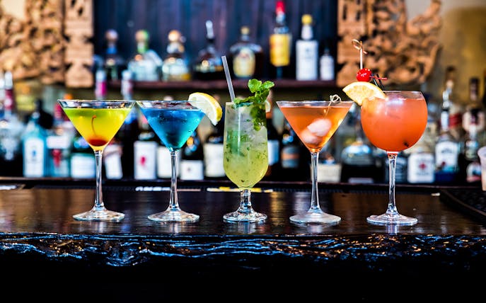 Colorful cocktails on a bar counter for Budapest boat tour with drink options.