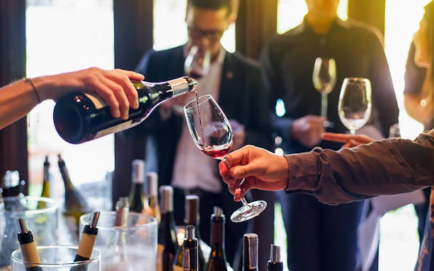 Wine being poured during a Budapest boat tour with drink options.