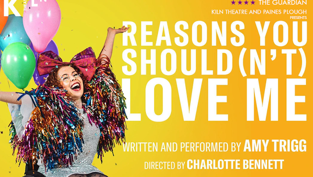 Performer in colorful costume with balloons, promoting "Reasons You Should(n’t) Love Me" at Kiln Theatre.