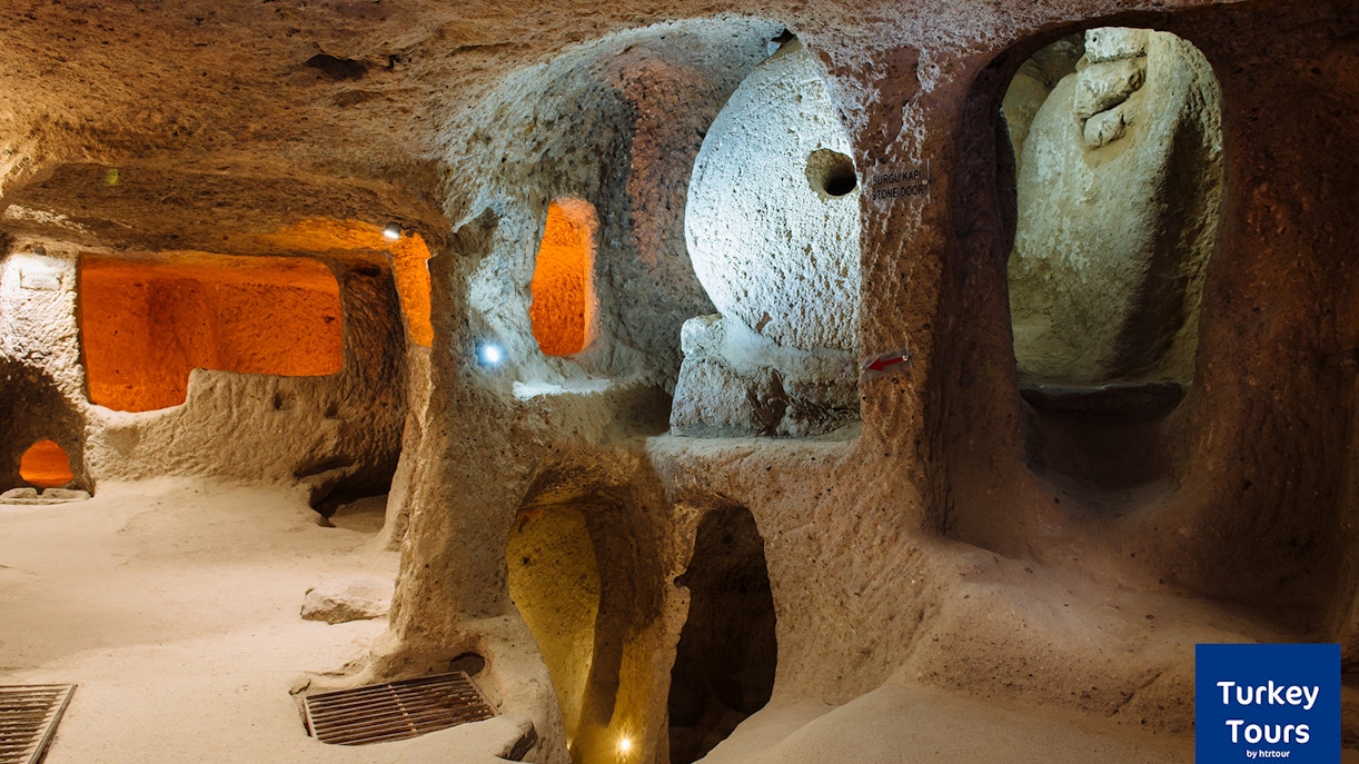 Underground city passage in Cappadocia, Turkey, with stone arches and illuminated chambers.