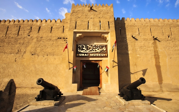 Dubai Museum entrance with cannons and flags, part of Snapshot Tour of Dubai.
