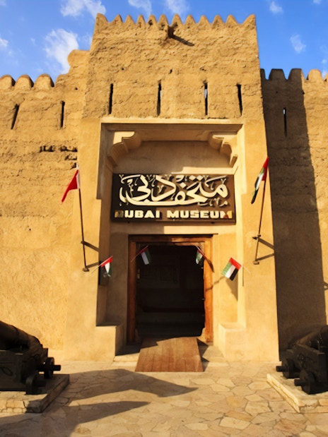 Dubai Museum entrance with cannons and flags, part of Snapshot Tour of Dubai.