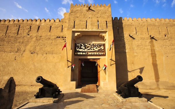 Dubai Museum entrance with cannons and flags, part of Snapshot Tour of Dubai.