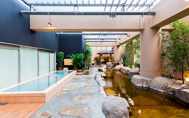 Spa LaQua indoor hot spring area with natural stone and greenery in Tokyo.