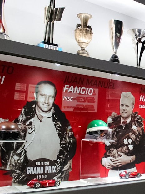 Trophies and racing memorabilia at Ferrari Museum Maranello, featuring famous drivers.