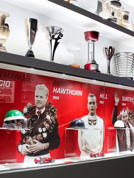 Trophies and racing memorabilia at Ferrari Museum Maranello, featuring famous drivers.