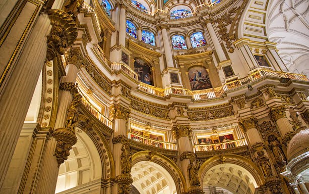 Royal Chapel of Granada interior with ornate columns and stained glass windows.
