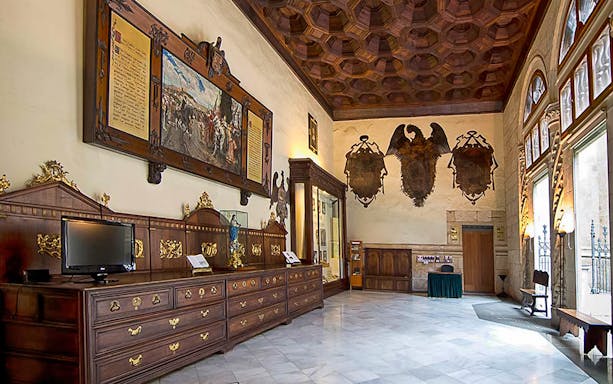 Royal Chapel of Granada interior with ornate wooden furniture and historical artwork.