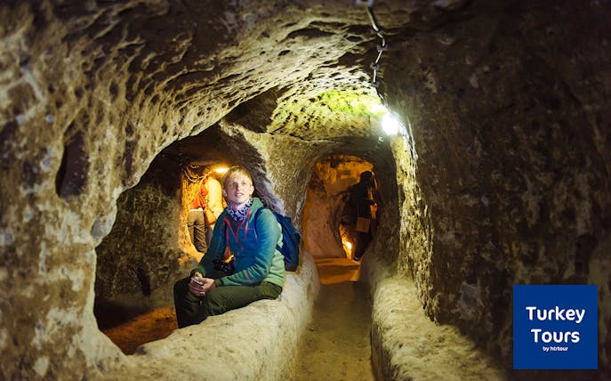 Tourists exploring underground cave in Cappadocia during Green Tour with Ilhara Valley.