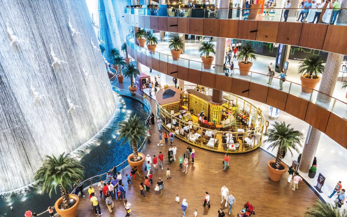 Dubai Mall waterfall with shoppers and dining area, part of the Guided Tour of Dubai Modern City & Monorail Ride.