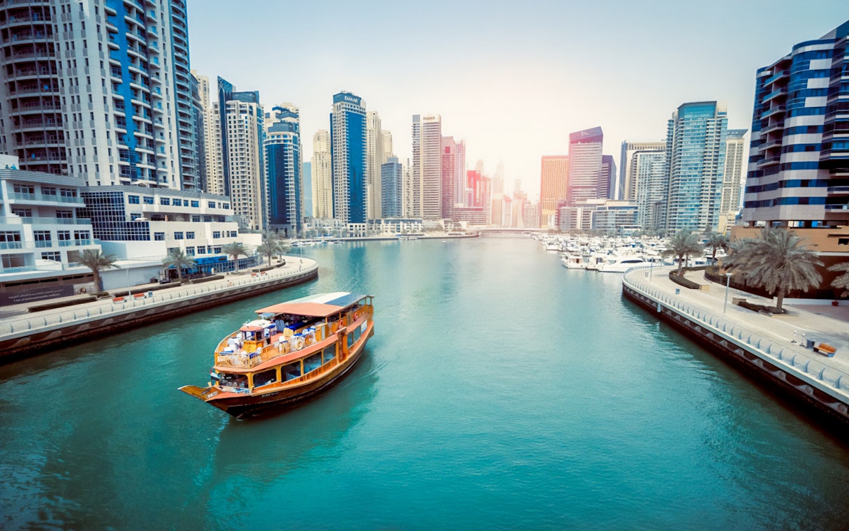 Dubai Marina with traditional boat and skyscrapers, part of the Guided Tour of Dubai Modern City & Monorail Ride.