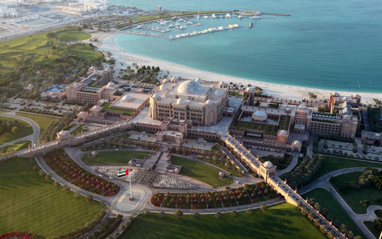 Aerial view of Emirates Palace in Abu Dhabi with surrounding gardens and marina.
