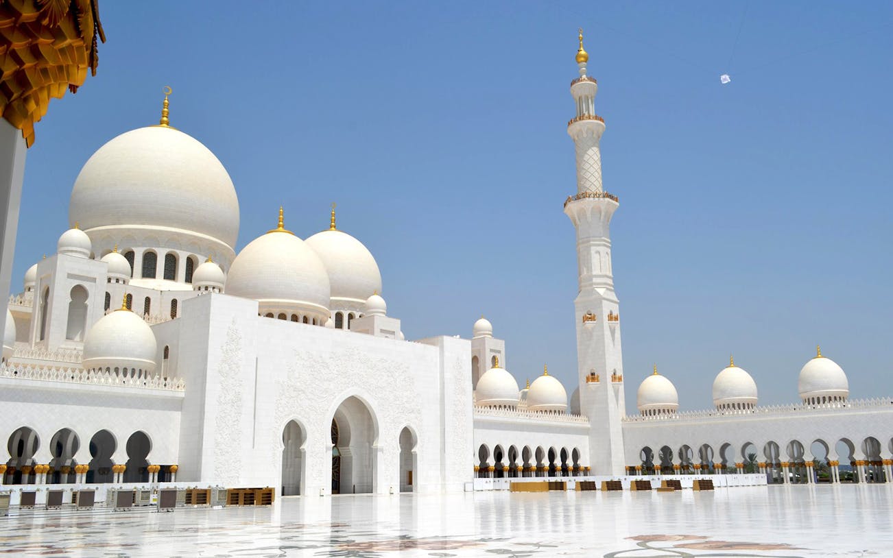 Sheikh Zayed Grand Mosque domes and minaret in Abu Dhabi under clear sky.