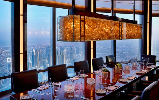 Dining table with city view in Dubai skyscraper during private night tour.