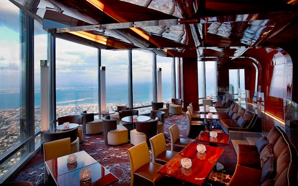 Dubai night tour dining experience with city view from high-rise restaurant.