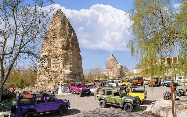 Jeep convoy parked near rock formations in Cappadocia during guided off-road tour.