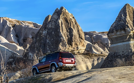 Off-road jeep navigating rocky terrain in Cappadocia during guided tour.