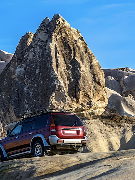 Off-road jeep navigating rocky terrain in Cappadocia during guided tour.