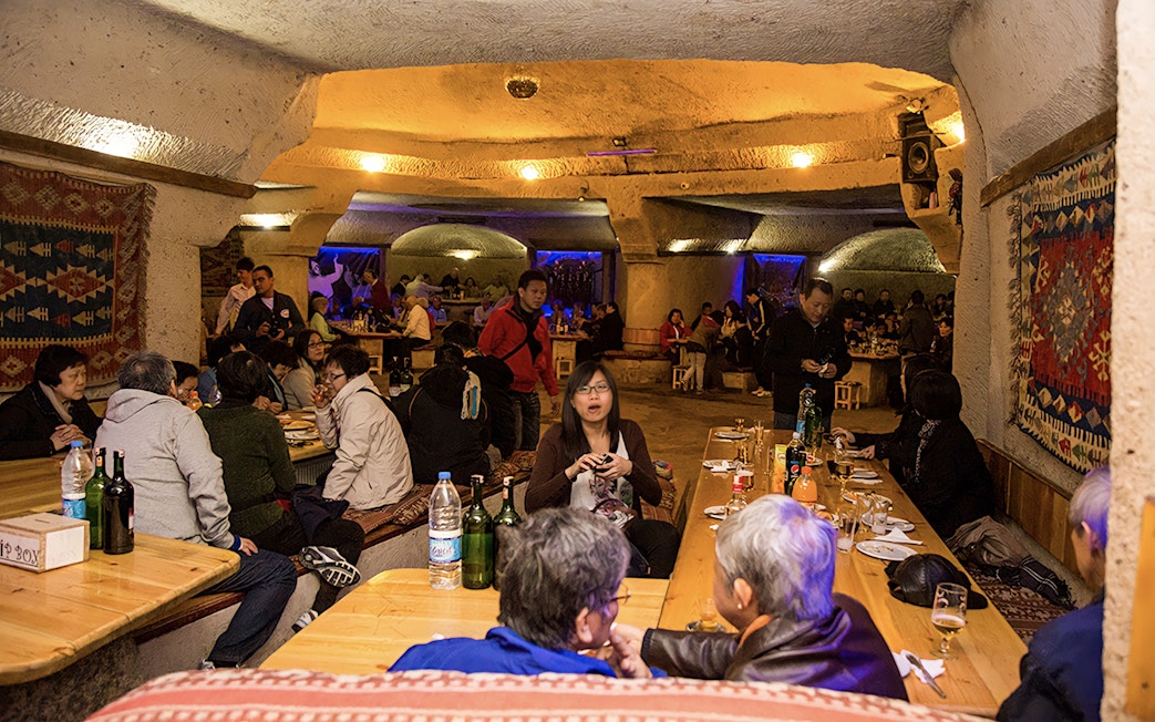 Guests dining in a cave restaurant during Turkish Night in Cappadocia.