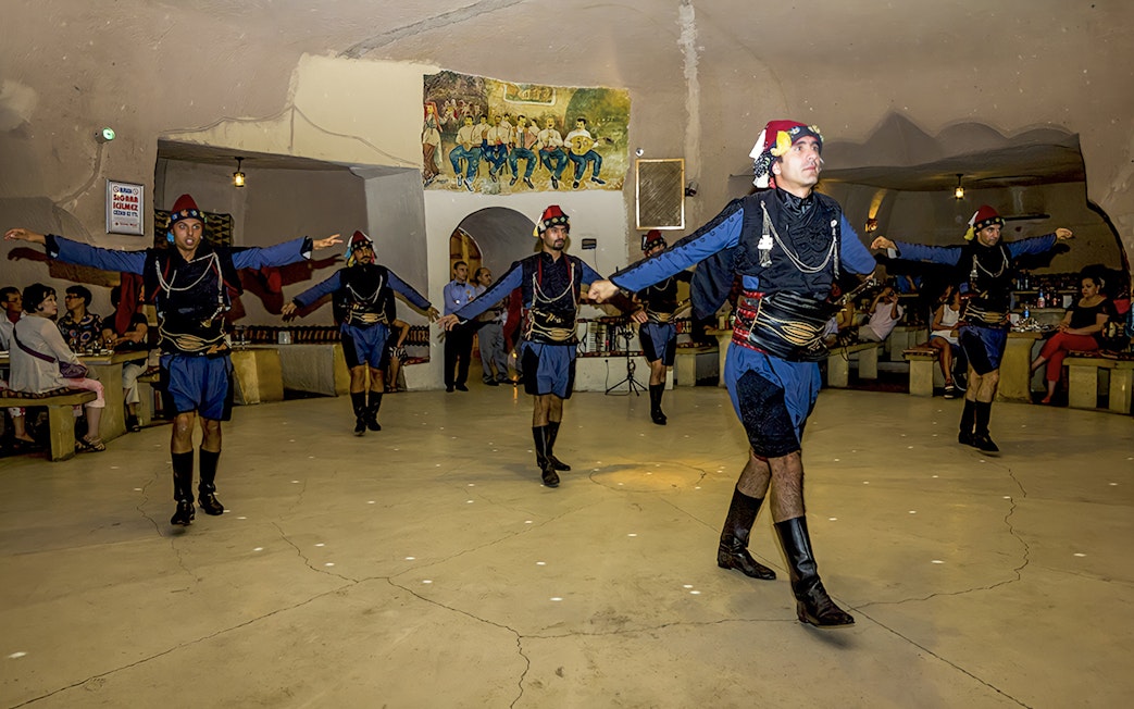 Traditional dancers performing in a cave restaurant in Cappadocia during a Turkish Night event.