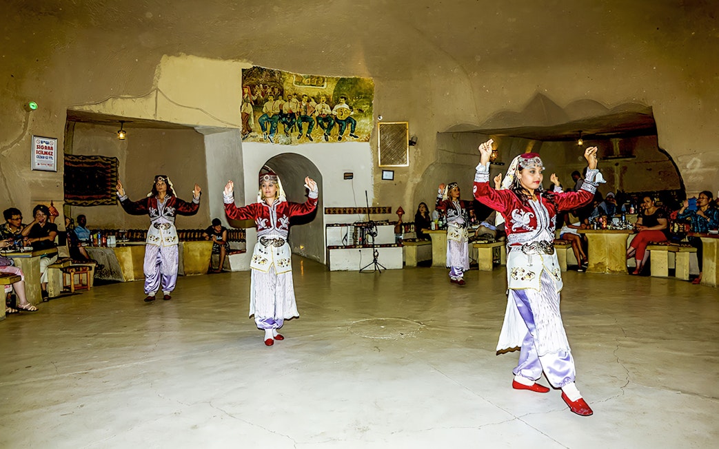 Traditional dancers performing in a cave restaurant in Cappadocia during a Turkish Night event.