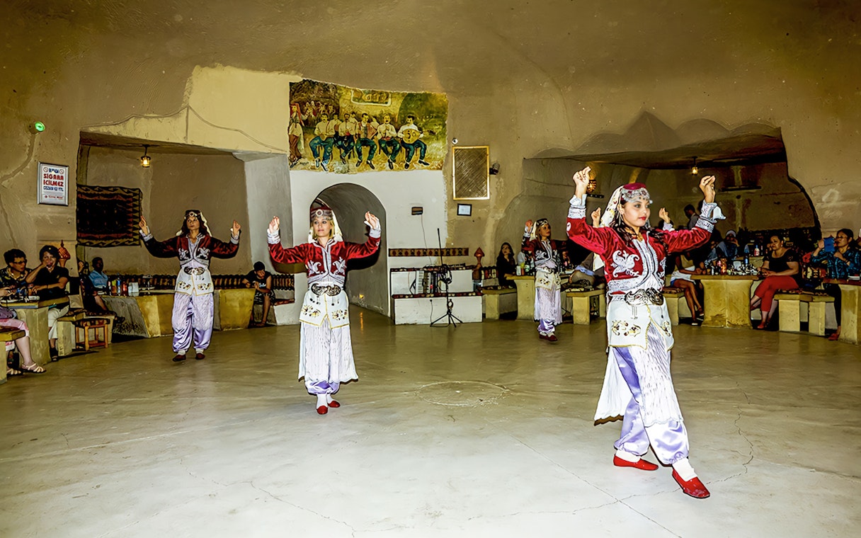 Traditional dancers performing in a cave restaurant in Cappadocia during a Turkish Night event.