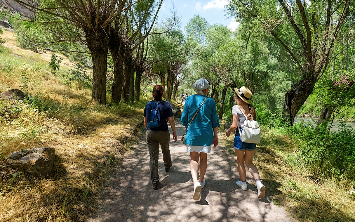 Tourists walking through a tree-lined path in Cappadocia during a private tour.