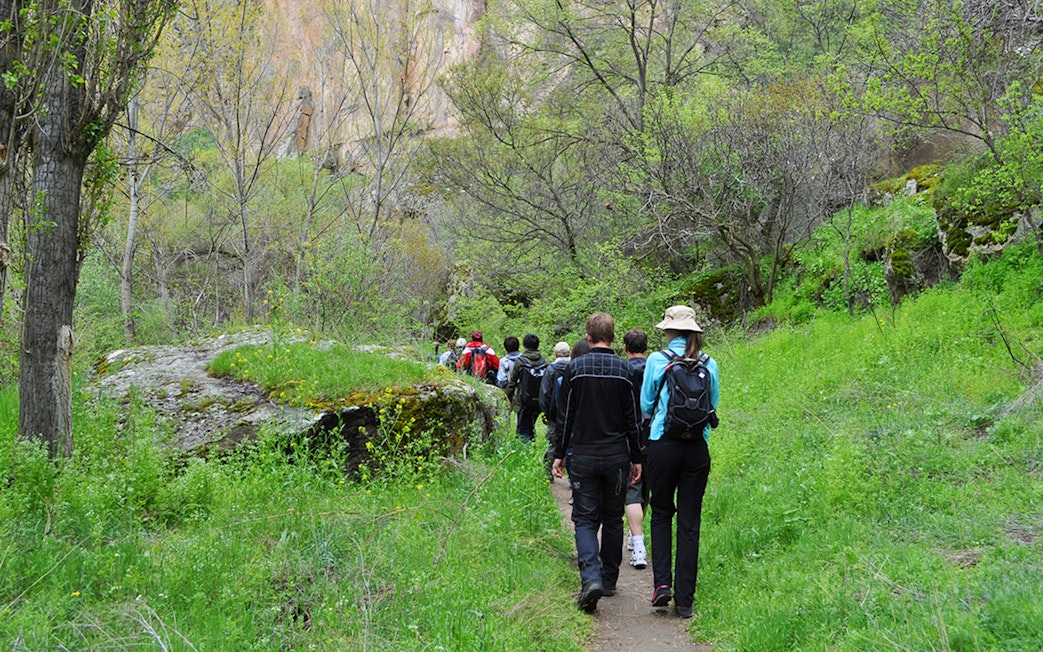 Group trekking through lush Ihlara Valley on Cappadocia Green Tour.